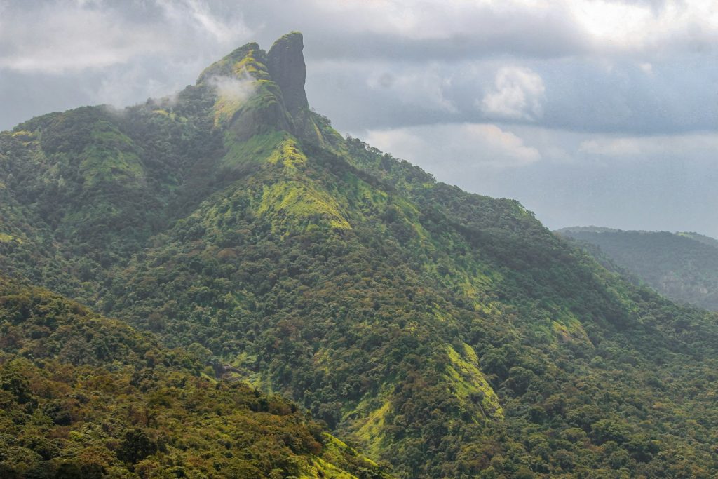 green and gray mountain under white clouds during daytime