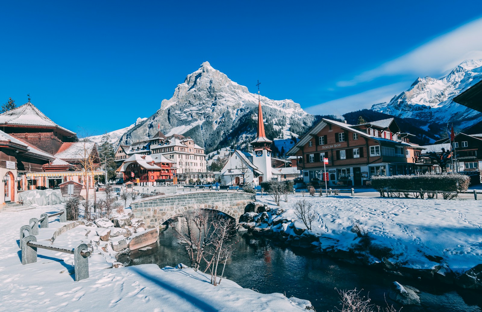 houses covered with snow near the mountain during daytime